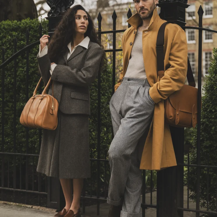 Woman and man holding the Chetham Bag in Tan and Clifton bag